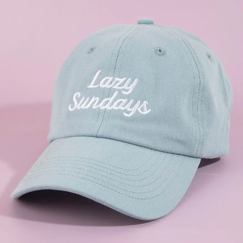 Soft sage blue baseball cap with Lazy Sundays white embroidery on pink background