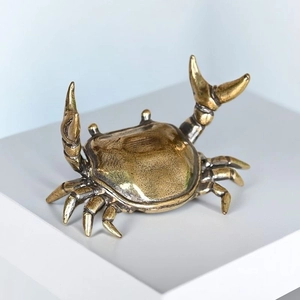 Antique gold brass crab figurine in weightlifting pose with detailed metal casting, shown on white shelf as desk ornament and pen rest