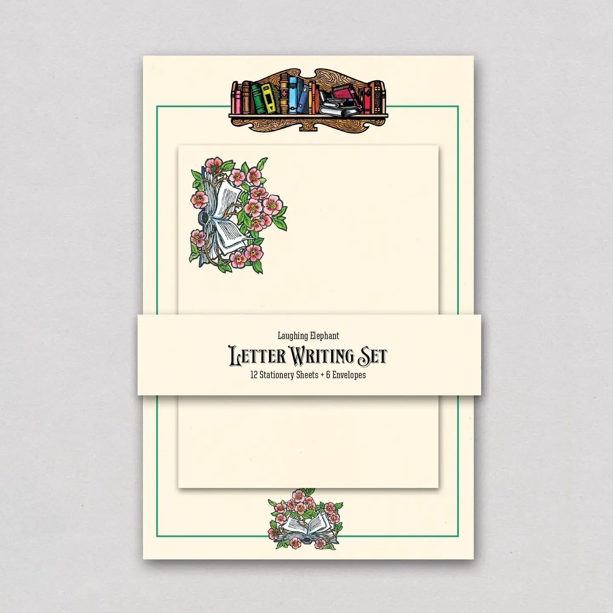 Shelf of Books Letter Writing Set by Laughing Elephant showing cream stationery sheets with colorful bookshelf header and floral open book footer, with envelope, bound with cream belly band, on gray background