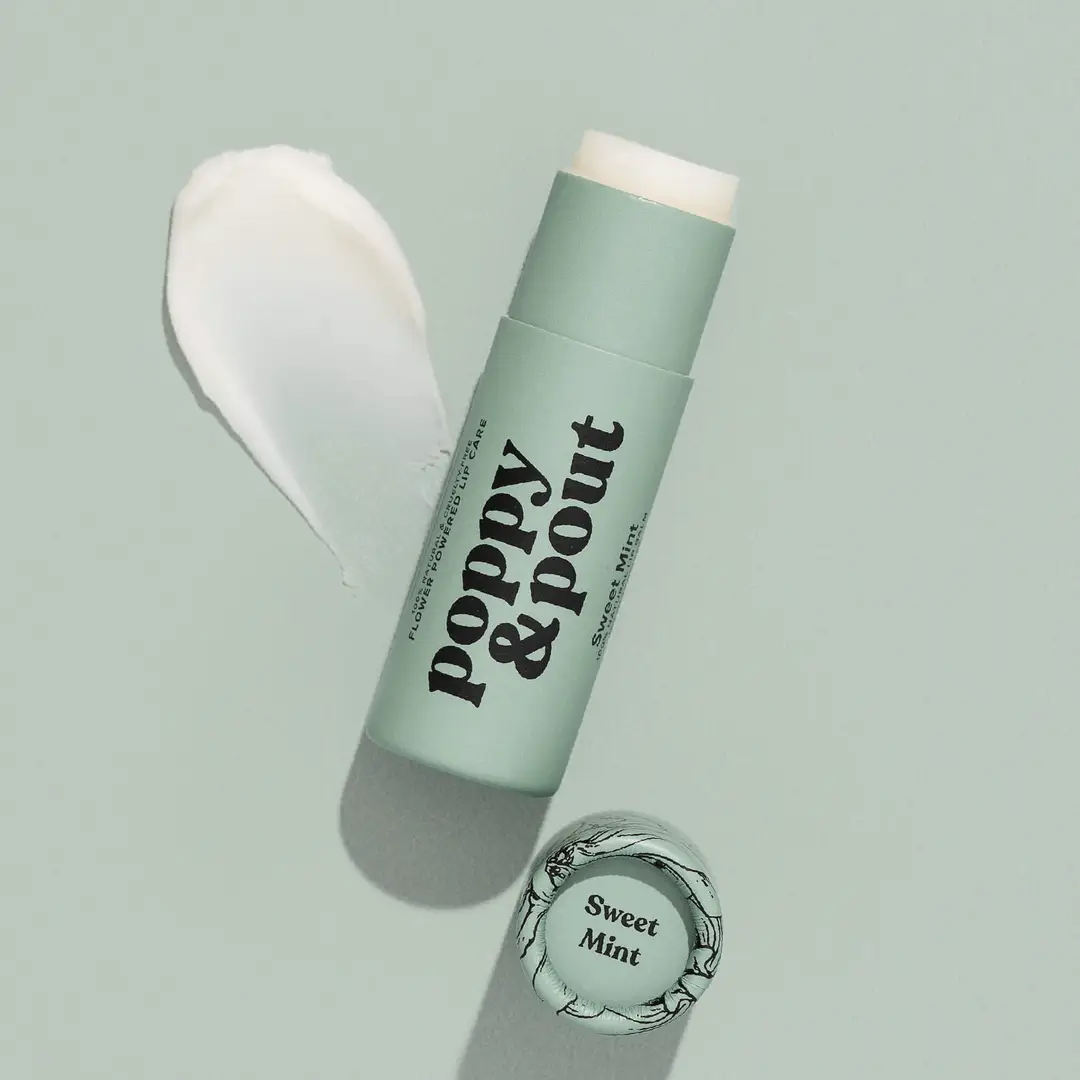 Poppy and Pout Sweet Mint lip balm in sage green tube with floral cap on mint green background